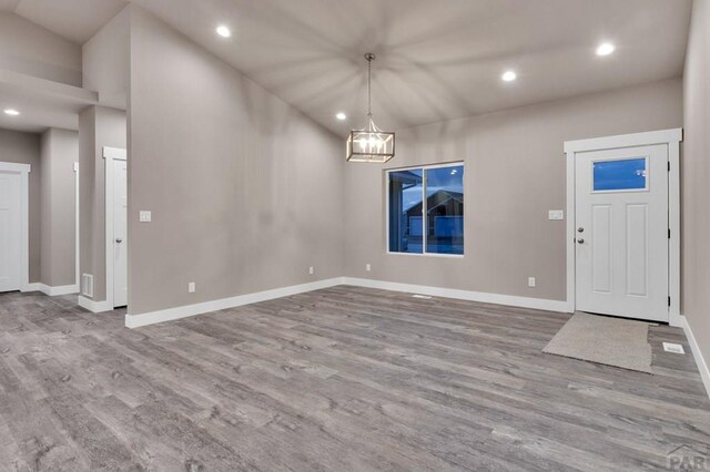 foyer with baseboards, a chandelier, wood finished floors, and recessed lighting