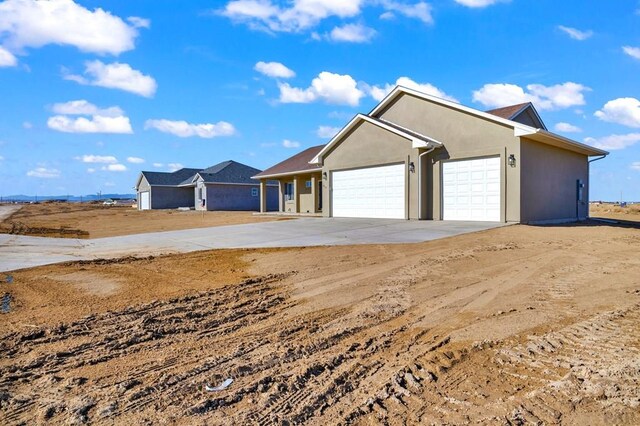 view of front of home featuring concrete driveway, an attached garage, and stucco siding