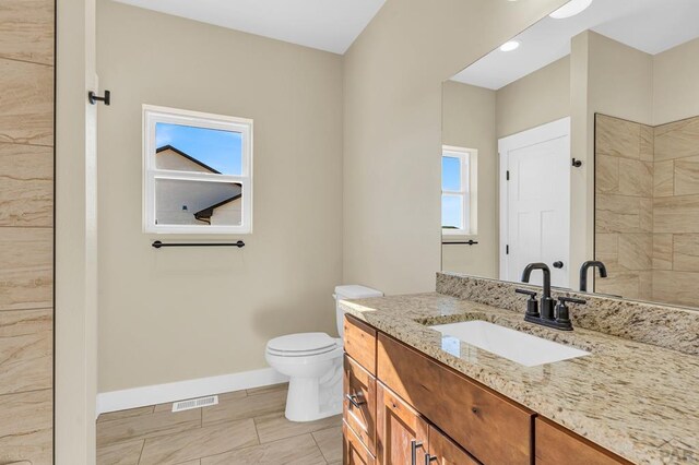 bathroom featuring toilet, baseboards, visible vents, and vanity