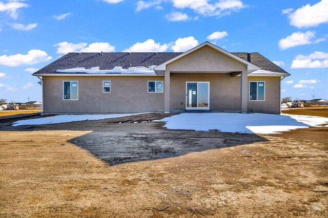 back of property with roof with shingles, a patio, and stucco siding