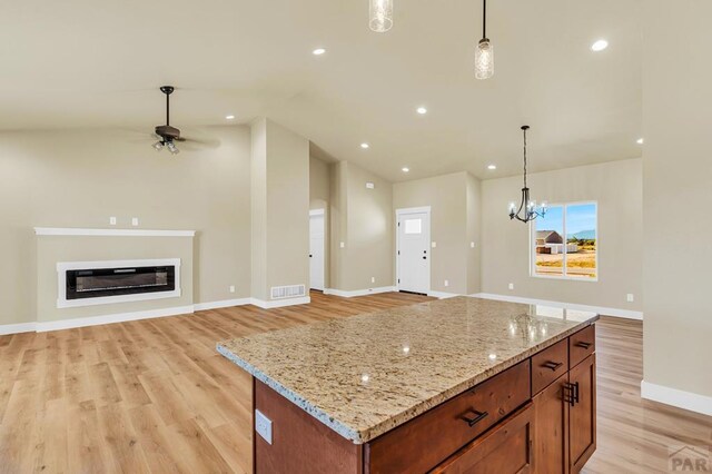 kitchen with pendant lighting, visible vents, a kitchen island, and open floor plan