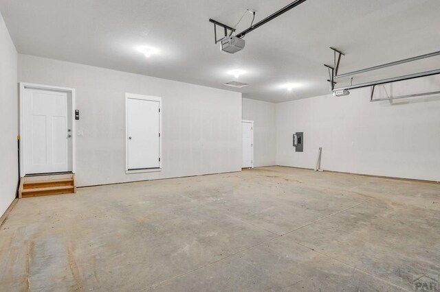 garage with electric panel and a garage door opener