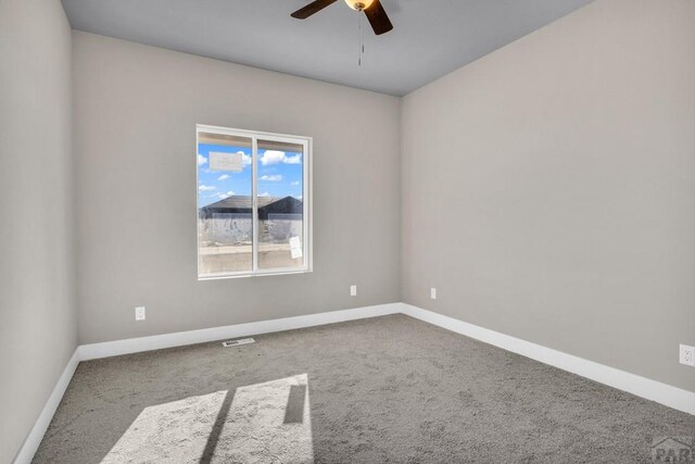 carpeted spare room with baseboards and a ceiling fan