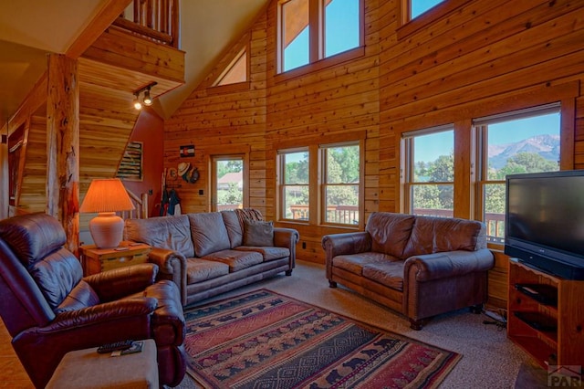 living room featuring carpet floors, wooden walls, and a towering ceiling