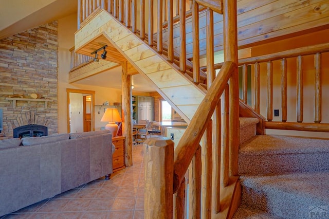 stairway featuring a fireplace, tile patterned flooring, and a towering ceiling