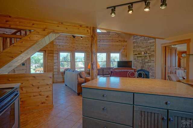 kitchen featuring plenty of natural light, wooden walls, gray cabinets, and light tile patterned flooring