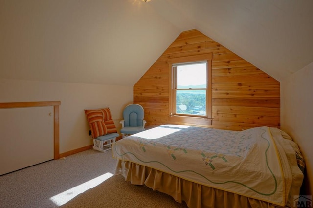 bedroom featuring carpet, wooden walls, and vaulted ceiling