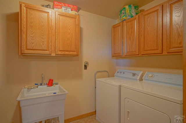 laundry area with washer and dryer, cabinet space, baseboards, and light tile patterned floors