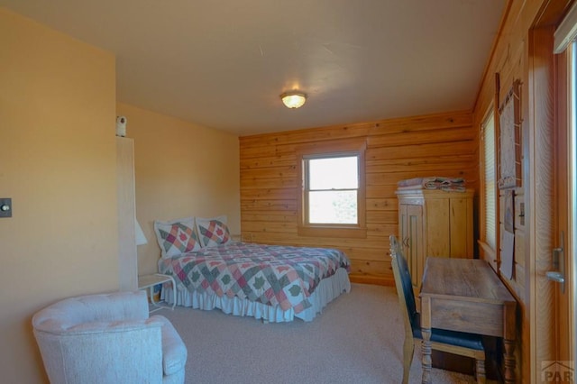 carpeted bedroom with wood walls