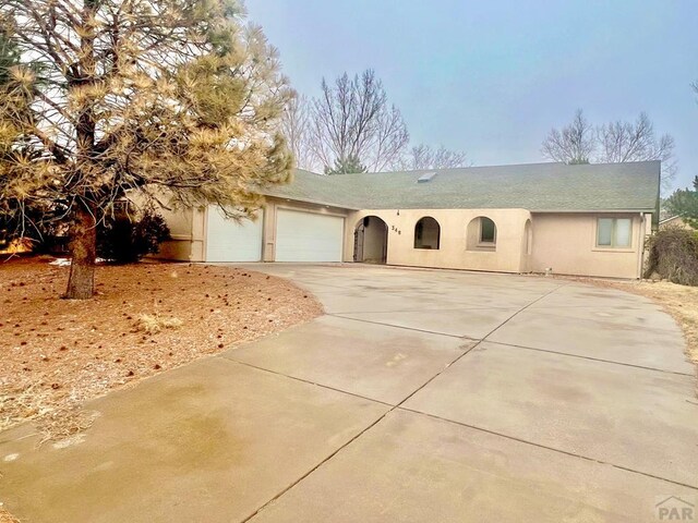 view of front of property with a garage, driveway, and stucco siding