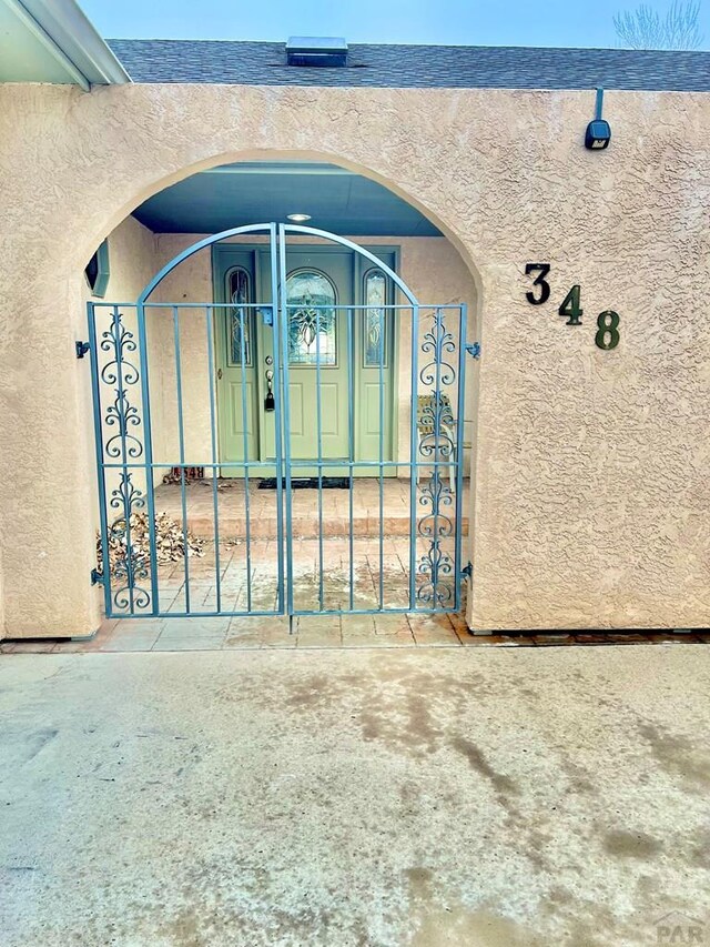 exterior space featuring a gate and stucco siding