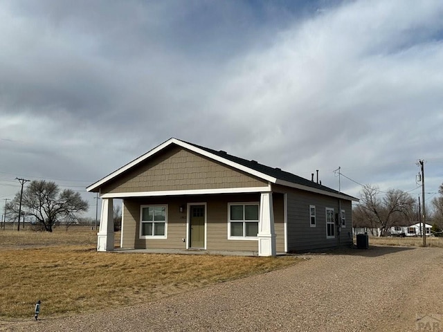 view of front of home with covered porch and a front lawn