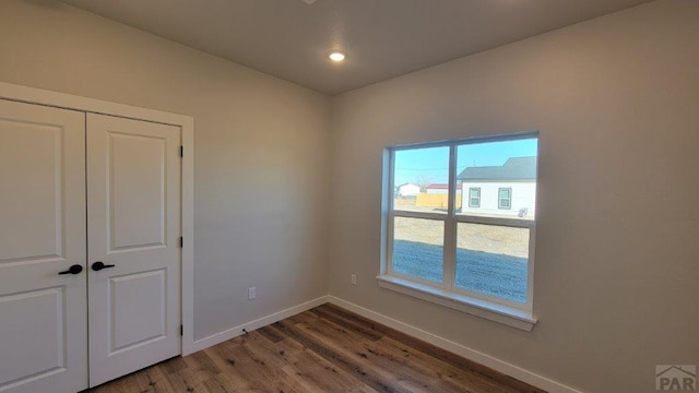 empty room featuring recessed lighting, baseboards, and wood finished floors