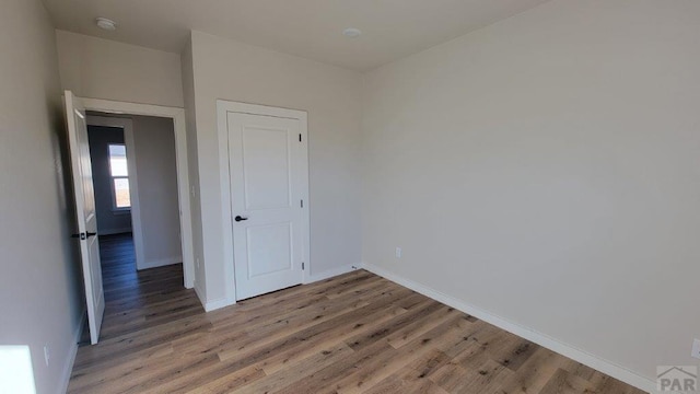 unfurnished bedroom with light wood-style flooring and baseboards