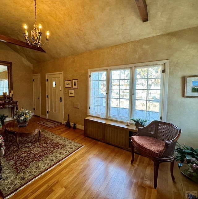 interior space featuring plenty of natural light, wood-type flooring, vaulted ceiling, and a notable chandelier