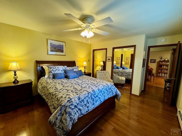 bedroom with ceiling fan, wood finished floors, and baseboard heating
