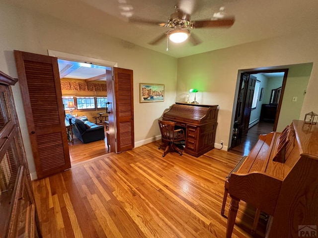 office space with baseboards, a ceiling fan, and wood finished floors