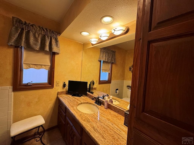 bathroom featuring toilet, a textured ceiling, vanity, and tile patterned floors