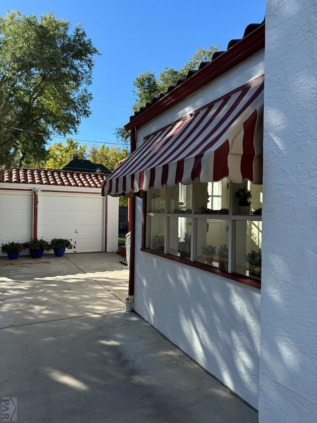 view of side of home with a tiled roof and stucco siding
