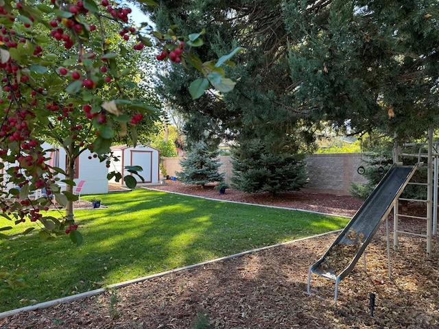 view of yard with a fenced backyard, an outdoor structure, and a storage unit