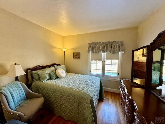 bedroom with baseboards and wood finished floors