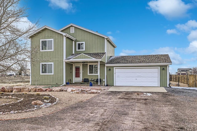 traditional-style home with dirt driveway, a shingled roof, an attached garage, and fence