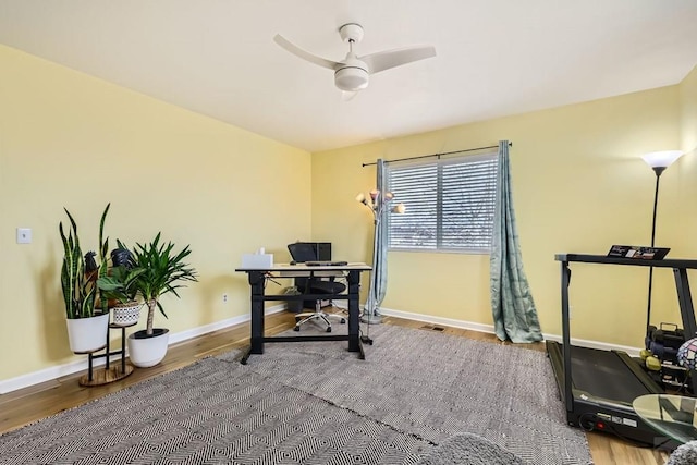 home office featuring ceiling fan, baseboards, and wood finished floors