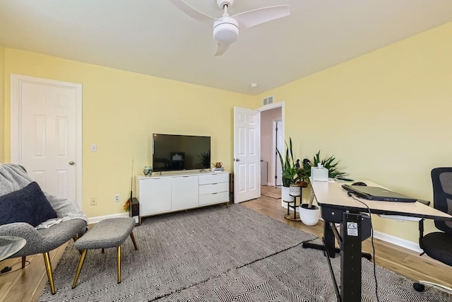 office with a ceiling fan, baseboards, visible vents, and wood finished floors