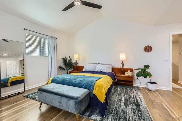 bedroom with ceiling fan, baseboards, vaulted ceiling, and wood finished floors