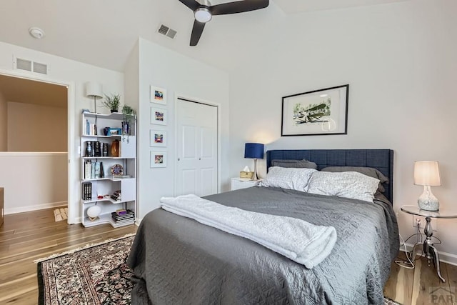 bedroom with a closet, wood finished floors, visible vents, and a ceiling fan