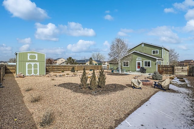 view of yard with a fire pit, a patio, a fenced backyard, an outbuilding, and a storage unit