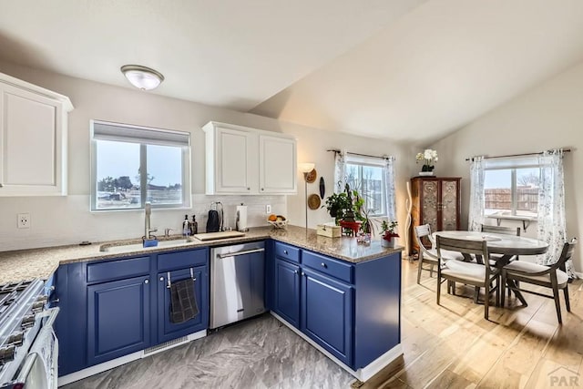 kitchen with stainless steel appliances, blue cabinets, white cabinetry, and a peninsula