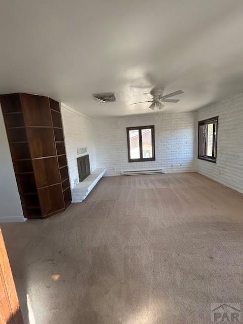 21 Terrace Dr, Pueblo, CO 81001 - unfurnished living room featuring plenty of natural light, a fireplace, a ceiling fan, carpet flooring, and brick wall