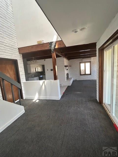 21 Terrace Dr, Pueblo, CO 81001 - unfurnished living room with brick wall and carpet floors
