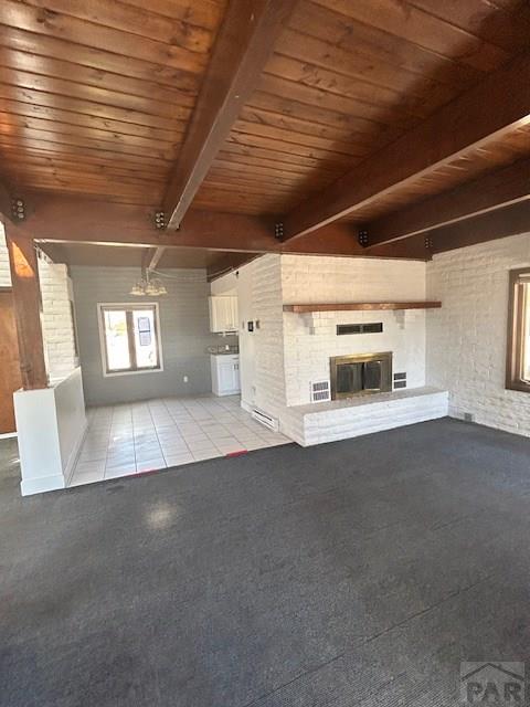 21 Terrace Dr, Pueblo, CO 81001 - unfurnished living room featuring wood ceiling, a fireplace, beamed ceiling, and carpet