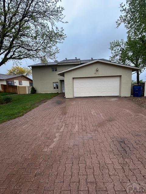 21 Terrace Dr, Pueblo, CO 81001 - view of front facade featuring decorative driveway, an attached garage, and stucco siding
