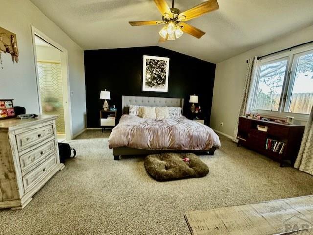 bedroom with light carpet, ceiling fan, vaulted ceiling, and baseboards