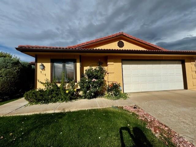 view of front of home with driveway, an attached garage, and stucco siding