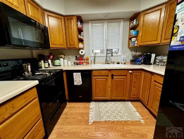 kitchen featuring black appliances, open shelves, and light countertops