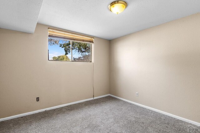 carpeted empty room with baseboards