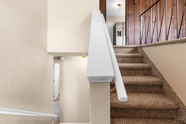 staircase featuring a textured wall