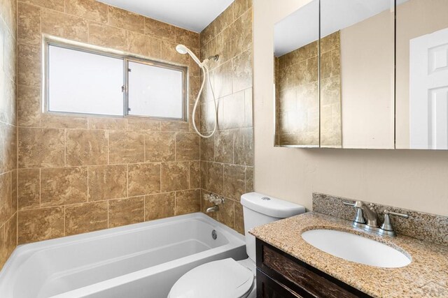 bathroom featuring toilet, vanity, and shower / bathtub combination