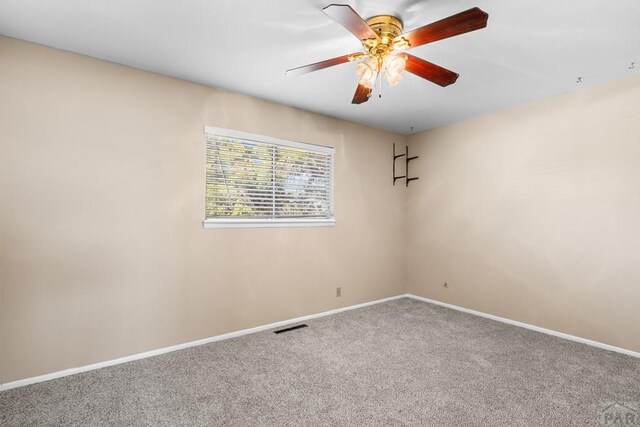 empty room with a ceiling fan, carpet, visible vents, and baseboards