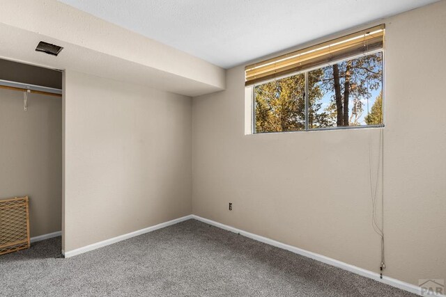 unfurnished bedroom with carpet, a closet, and baseboards