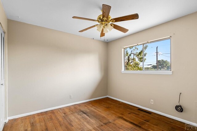 unfurnished room featuring ceiling fan, wood finished floors, visible vents, and baseboards