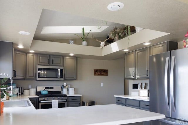 1108 W Meadowmoor Dr, Pueblo West, CO 81007 - kitchen with a peninsula, light countertops, lofted ceiling, and appliances with stainless steel finishes