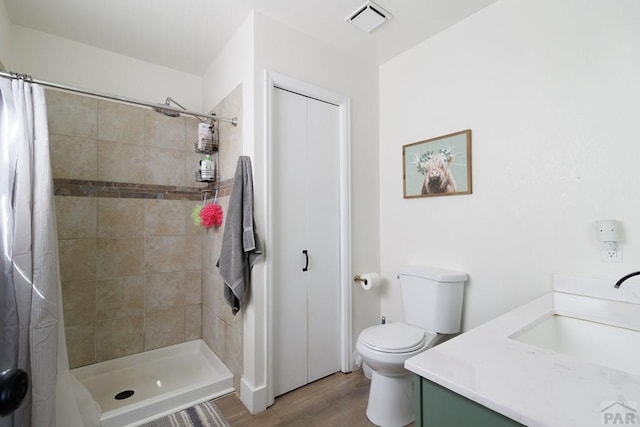 1108 W Meadowmoor Dr, Pueblo West, CO 81007 - bathroom with vanity, toilet, visible vents, a tile shower, and wood finished floors