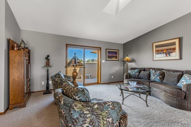 living room with lofted ceiling with skylight, carpet, and baseboards