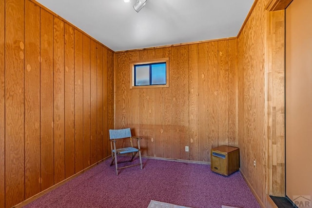 sitting room with carpet flooring and wood walls