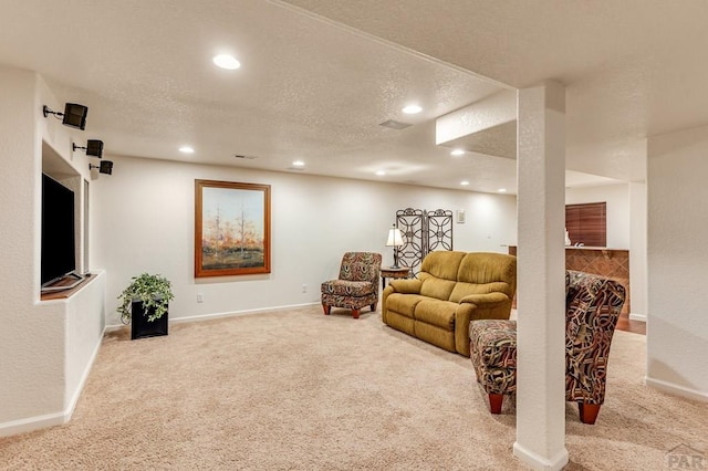 living area featuring a textured ceiling, recessed lighting, baseboards, and light colored carpet